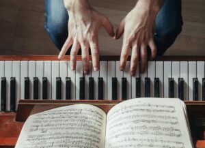 Hands at a piano with sheet music